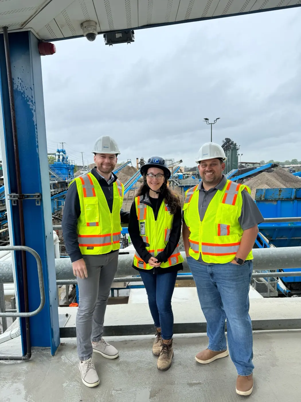 Three of the team in hard hats and hi-vis walking an aggregates plant.