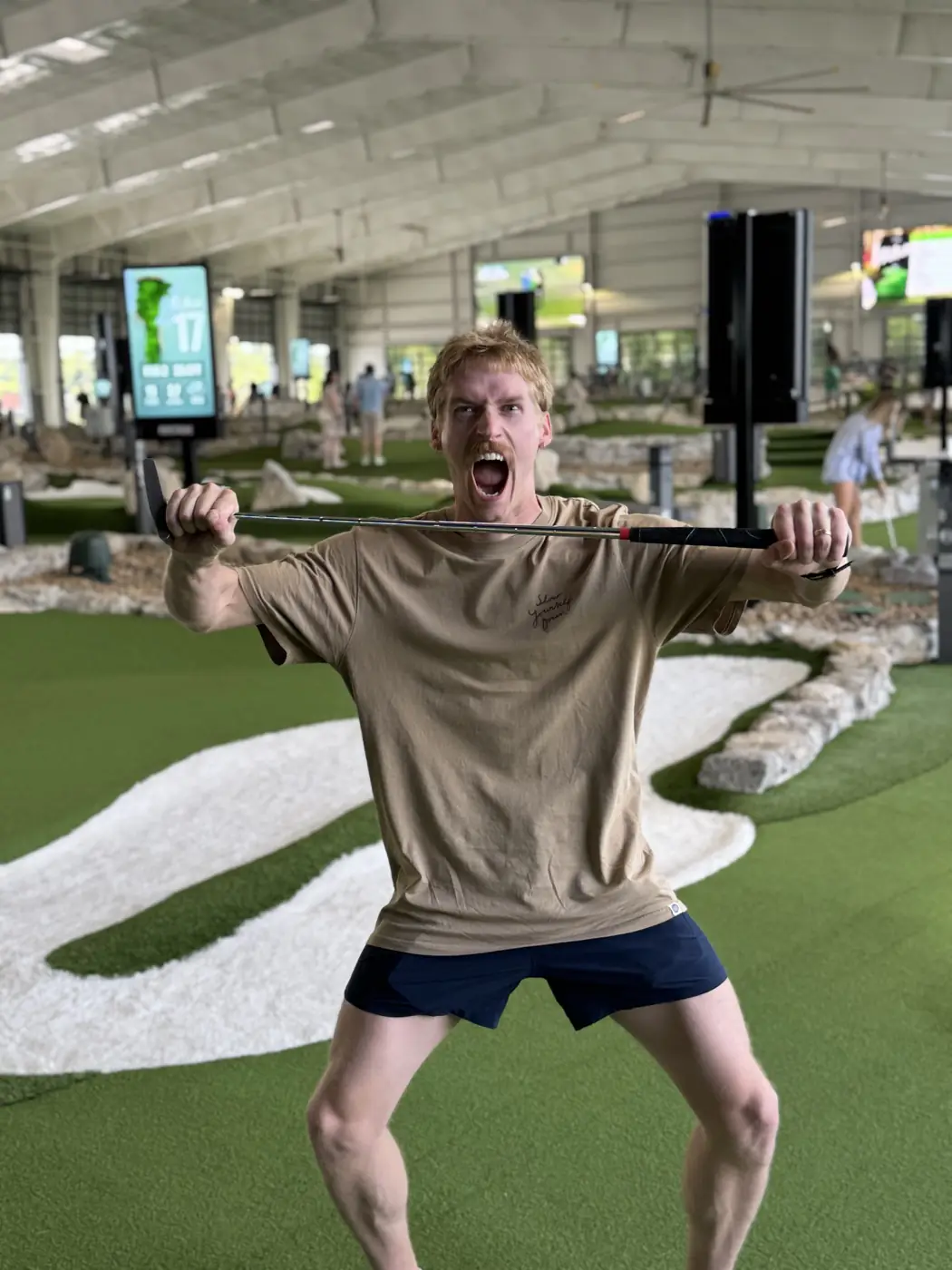A teammate mid-celebration, golf club held across their shoulders.